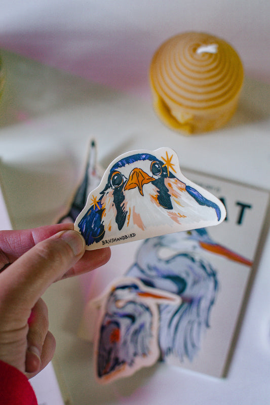Hand Holding a sticker of a Baby Kestrel design.