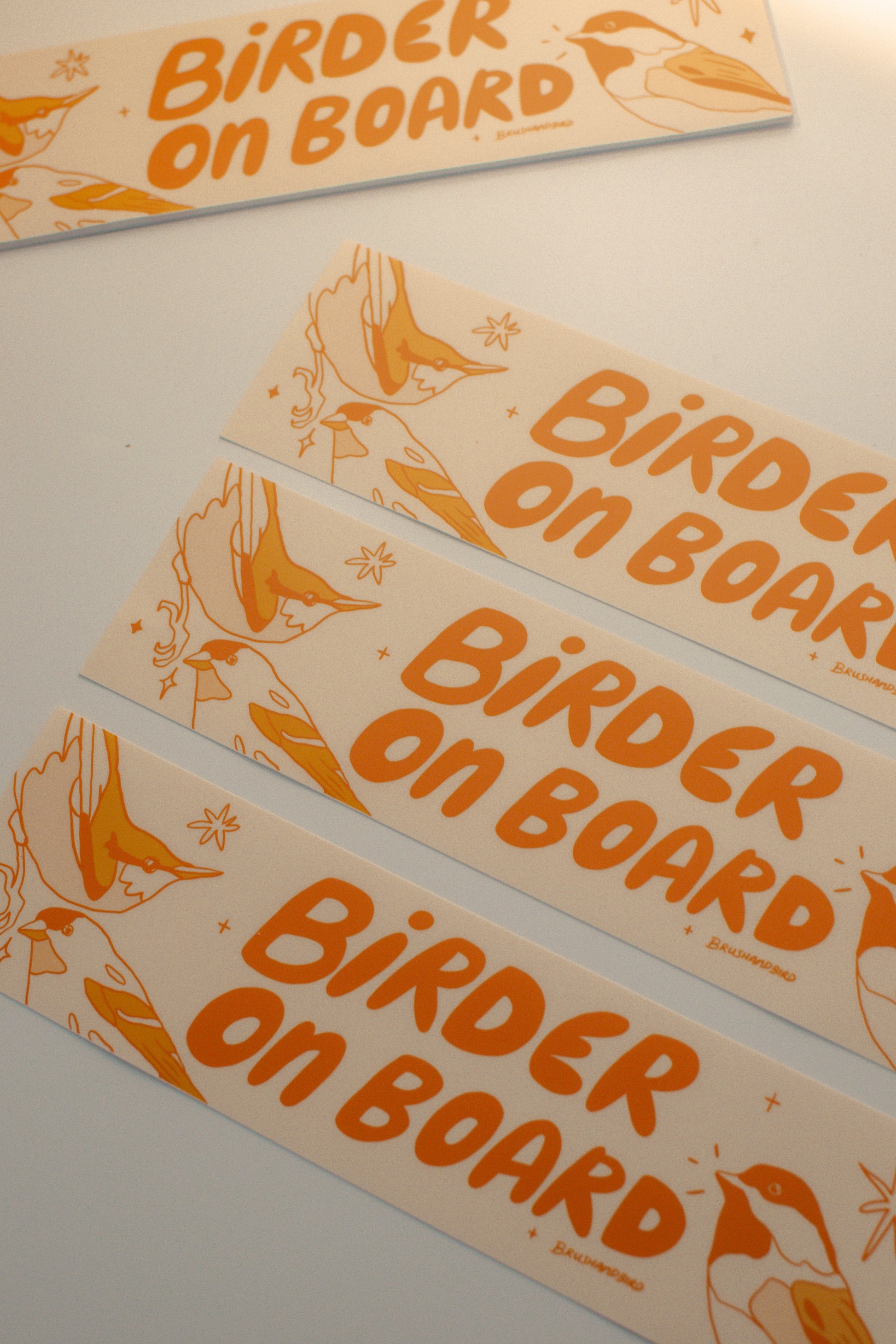 Multiple 'Birder on Board' bumper stickers with a bird illustration on a light background