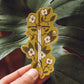 A sword entwined by flowers and thorns on a vibrant green background